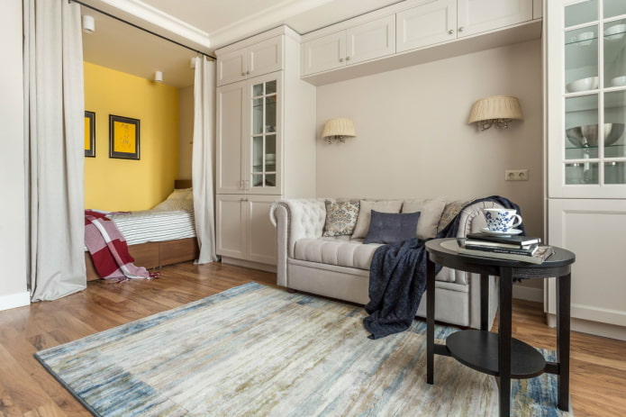 Bed behind curtains and sofa in the arch