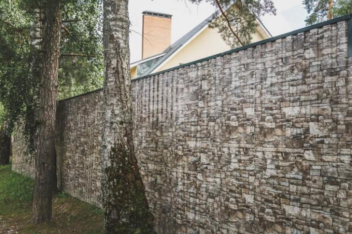 Fence made of corrugated board under a stone Fence made of corrugated board under a stone