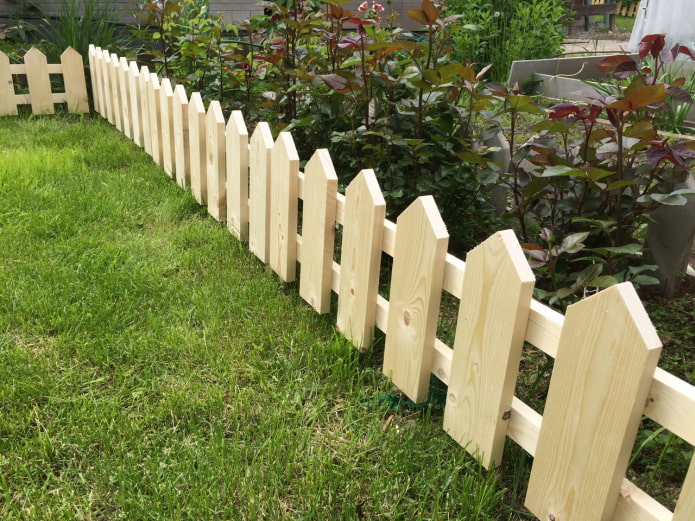 a fence for a flower garden from freshly planed boards