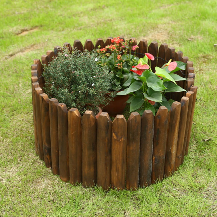 a fence made of boards around a mini-flower bed