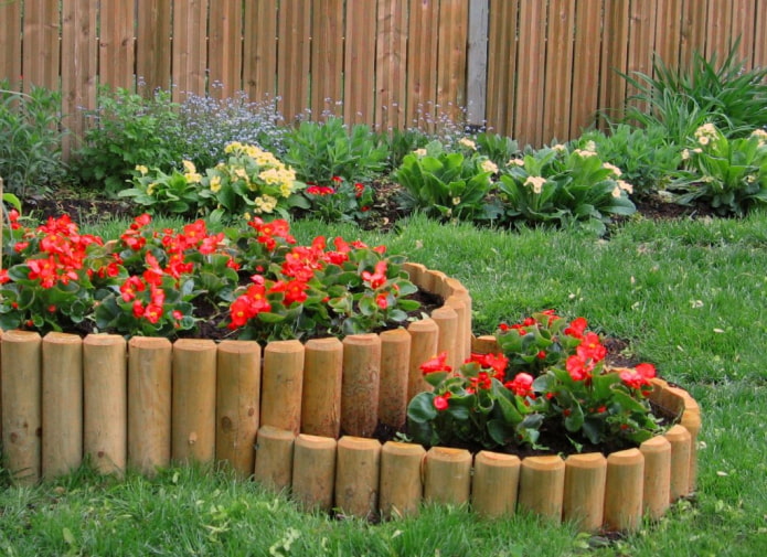 two-level flowerbed with a side made of stakes sawn in two