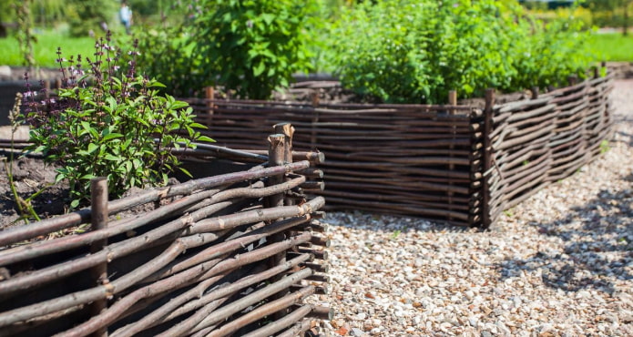rectangular flower beds with a side woven from dark thin branches