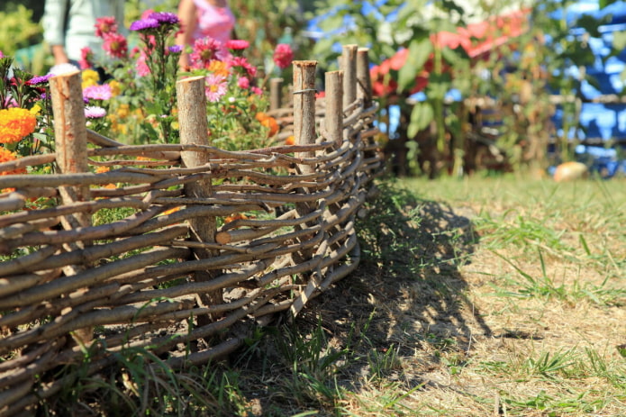 wicker fence for a flower garden from light thin branches