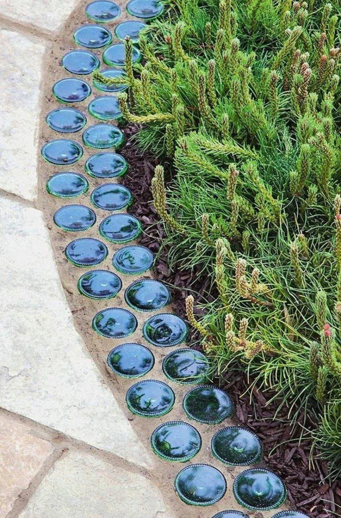 border for a flower bed from the bottoms of glass bottles embedded in cement
