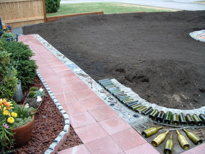 composition of glass bottles on the border of the flower garden
