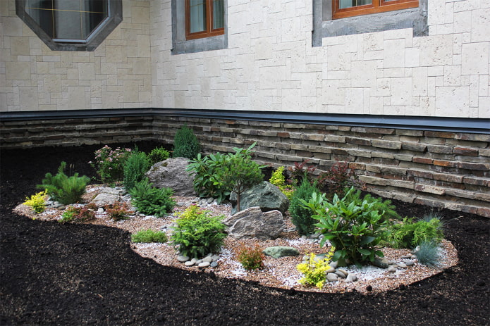 flowerbed with stones near the house